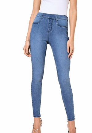 Vysoké modré skinny džínsy vyrobené z denimu, s hladkou textúrou, tradičným dizajnom piatich vreciek a prešívaním pozdĺž švov.