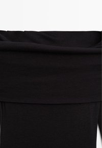 Black off-the-shoulder top made of soft, smooth fabric with a wide neckline. Features a fitted silhouette and subtle stretch texture.