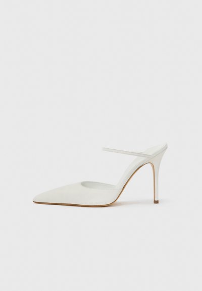 Scarpa bianca con tacco alto, punta affilata e retro aperto. Presenta una sottile cinghietta alla caviglia e una superficie testurizzata. Il tacco a stiletto è sottile e affusolato.