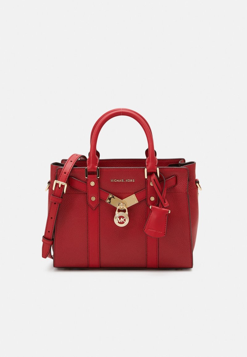 Sac à main en cuir rouge texturé avec double poignées, bandoulière réglable, serrure dorée et logo Michael Kors sur le devant.