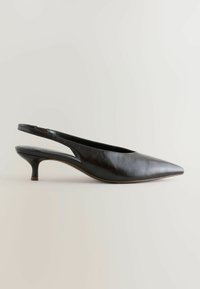 Svart slingback-pumps med spetsig tå och låg klack, placerad på en ljus bakgrund. Enkel och elegant design.