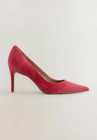 Vaaleanpunaiset mokkanahkakengät korkean korolla, terävässä kärjessä ja kapeassa stiletto-korossa. kengässä on sileä pinta ja matala leikkaus edessä.
