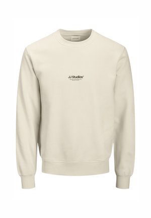Light beige sweatshirt made of soft fabric, featuring a crew neck, long sleeves, and a small black logo printed on the chest.