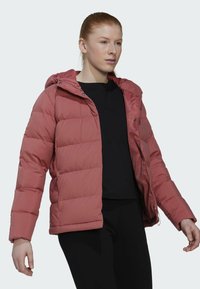 Padded jacket w stonowanym różu, z kapturem, zamkiem błyskawicznym z przodu i elastycznymi mankietami. Gładka, błyszcząca tekstura z pikowanym wzorem dla zapewnienia ciepła.