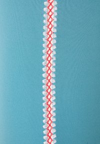 Tkanina v akvamarínové barvě se svislým červeným a bílým dekorativním stehem uprostřed, hladká textura a čistý, moderní design.