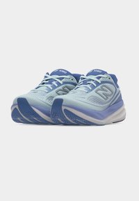 Ανοιχτό μπλε και μωβ αθλητικά παπούτσια New Balance 1080 για τρέξιμο με άνω μέρη από δίχτυ και κλείσιμο με κορδόνια, εμφανίζονται από μπροστινή γωνία.