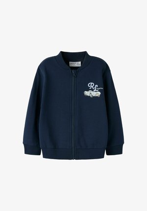 Giacca a zip blu navy in morbido tessuto. Presenta polsini e collo a coste. Decorata con un design di auto da corsa bianco e logo sul petto.