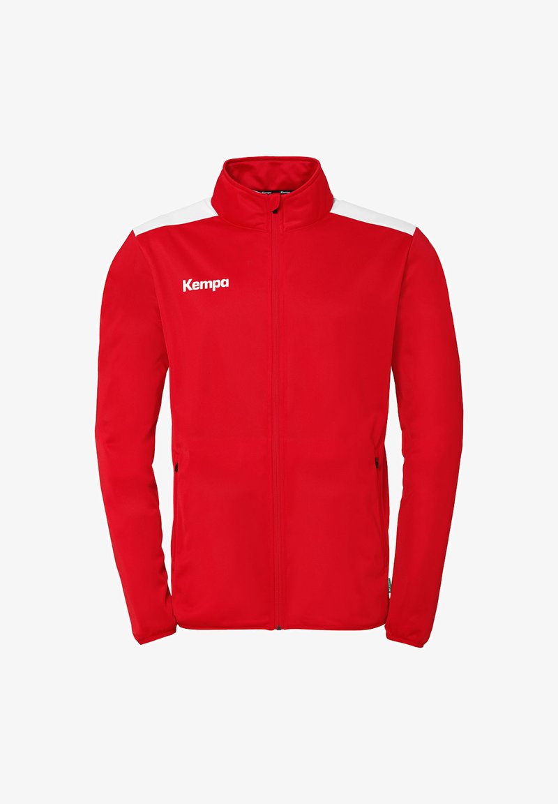 Rød atletisk jakke med hvide skulderdetaljer og høj krave. Har lynlås i sidelommerne og "Kempa" logo i hvidt på brystet.