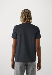 Schwarzes Baumwoll-T-Shirt mit kurzen Ärmeln, Rundhalsausschnitt und geradem Saum. Weicher Stoff, lässige Passform und minimalistisches Design.
