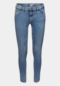 Jeans ajustados en denim azul claro, con un diseño clásico de cinco bolsillos, cierre de botón de metal y un ligero desgastado.