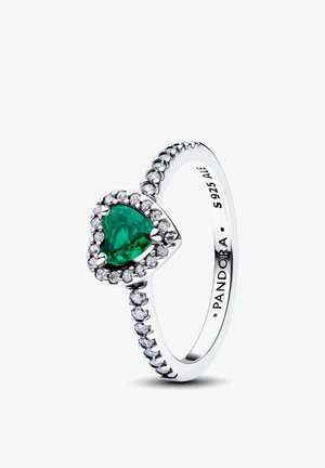 Bague en argent avec une pierre précieuse verte en forme de cœur au centre, entourée de petites pierres claires, gravée de "PANDORA S 925 ALE" à l'intérieur.