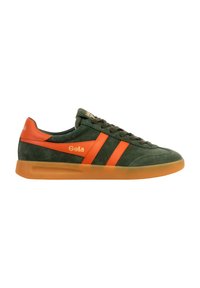 Zapatilla de ante verde oscuro con rayas naranjas, detalle naranja en el talón, logo "Gola" en el lateral y suela de goma translúcida marrón.