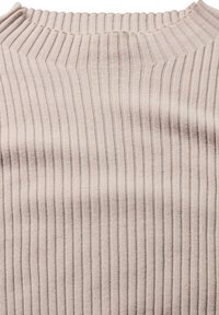 Beige gerippter Strickpullover mit hohem Kragen, der gleichmäßig verteilte vertikale Streifen und eine weiche Textur aufweist.