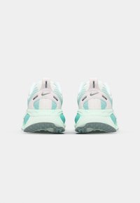 Nike-Laufschuhe mit einem leichten Mint- und weißen Mesh-Obermaterial, strukturierter grüner Sohle und Zugschlaufe an der Ferse. Merkmale sind das auffällige Logo und die Belüftung.