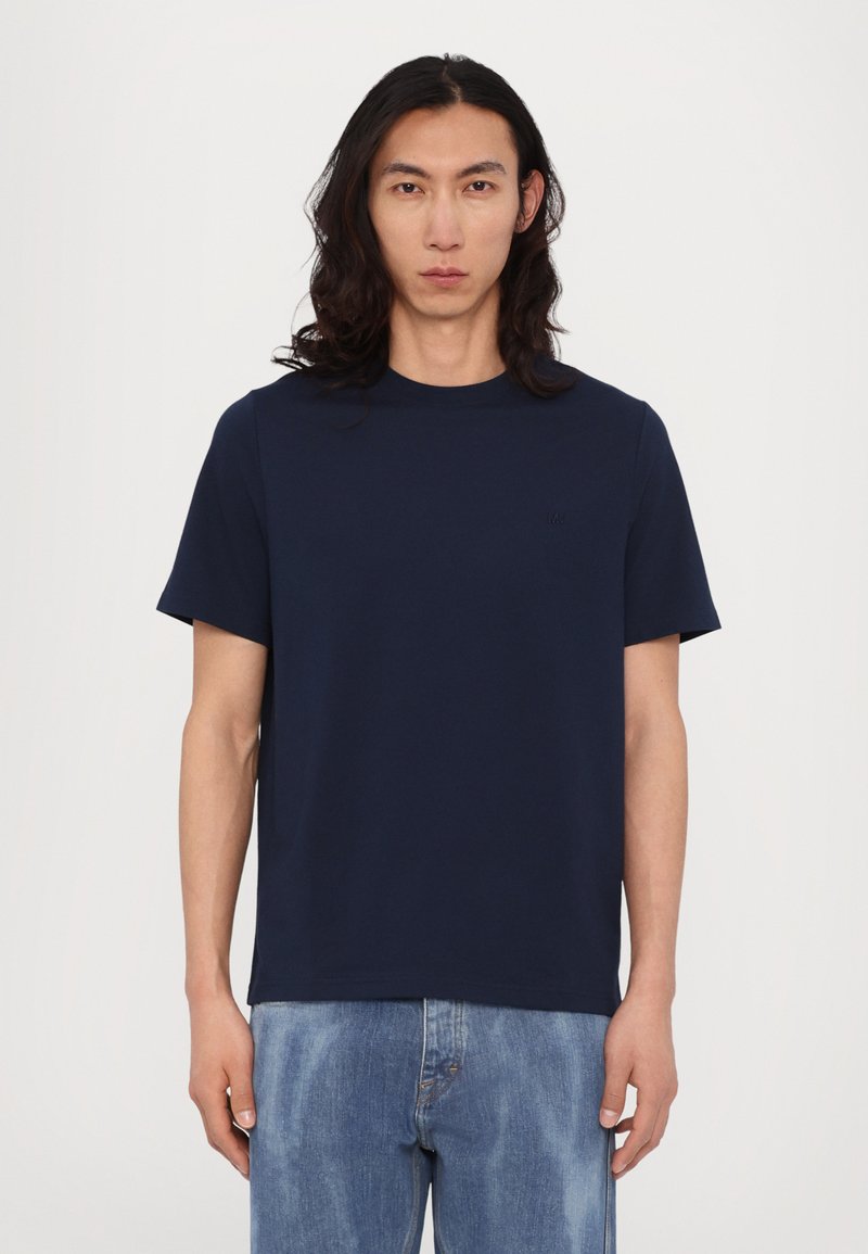 Tricou bleu marin cu mânecă scurtă, fabricat dintr-un amestec fin de bumbac, având un guler rotund și un logo brodat subtil pe piept.