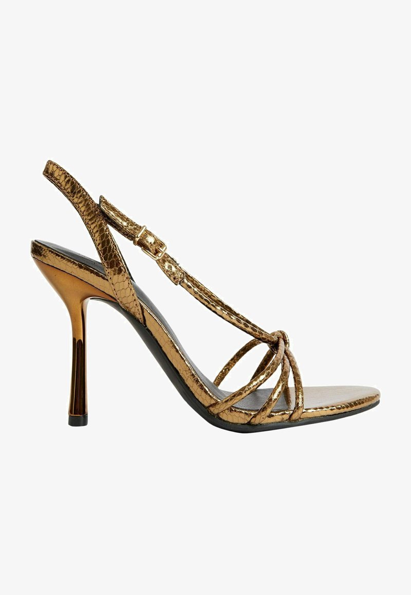 Sandały na wysokim obcasie z paskami w metalizowanym złotym kolorze imitującym węża, o smukłym designie, z odkrytymi palcami i paskiem na kostkę z klamrą w złotym odcieniu.