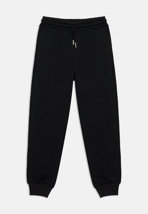 Sort joggingbukser med elastisk talje, snøre, sidelommer, ribkant ved anklerne og diskret Calvin Klein-logo på venstre ben.