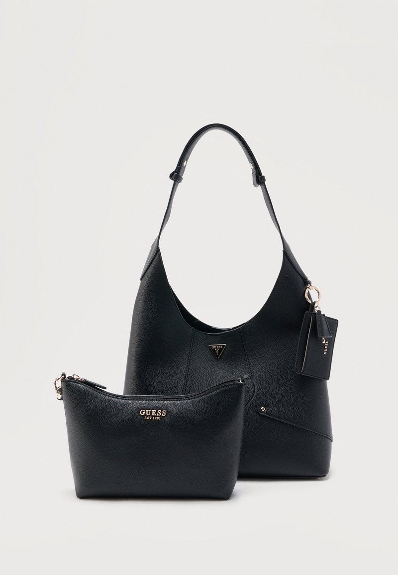 Sac à main Guess en cuir noir avec bandoulière réglable, petite pochette zippée et porte-clés attaché sur fond blanc uni.