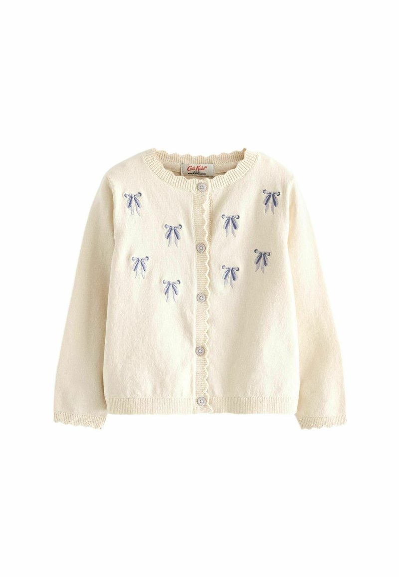 Ker cardigan krem terbuat dari kain lembut, dilengkapi dengan pita bordir biru, leher bulat, penutupan kancing, dan trim bergelombang di sepanjang tepinya.