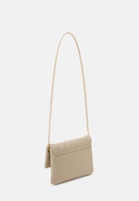 Sac bandoulière rectangulaire beige avec rabat matelassé et chaîne dorée sur fond blanc.