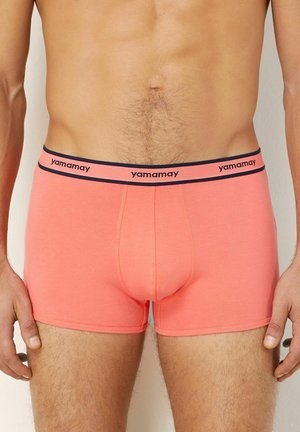 Boxer-briefs pour hommes corail avec une ceinture bleue marine affichant le nom de la marque "yamamay". Fabriqués en tissu doux, avec un design ajusté et une longueur jusqu'aux mi-cuisse.