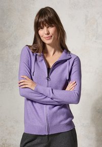 Sweater zippé violet clair avec une capuche et des poignets côtelés. Présente des rayures horizontales et un cordon de serrage au niveau du cou.