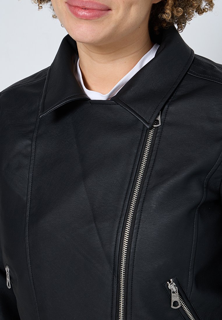 Giacca di pelle nera con colletto strutturato, chiusura con zip diagonale e due tasche con zip. Il materiale ha una texture liscia.