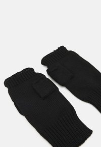 Zwarte gebreide vingerloze handschoenen met geribde manchetten en een klein, rechthoekig patchdetail. Zachte textuur en eenvoudig ontwerp voor handblootstelling.
