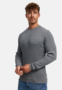 Grå strikket genser med ribbestruktur og rund hals, med en tettsittende silhuett og lange ermer. Uformell design med minimalt med detaljer.