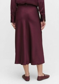 Burgundyröd satin midi kjol med en slät textur, en åtsittande midja och en lätt A-linjeform. Bak har den en liten centrerad knappdetalj.