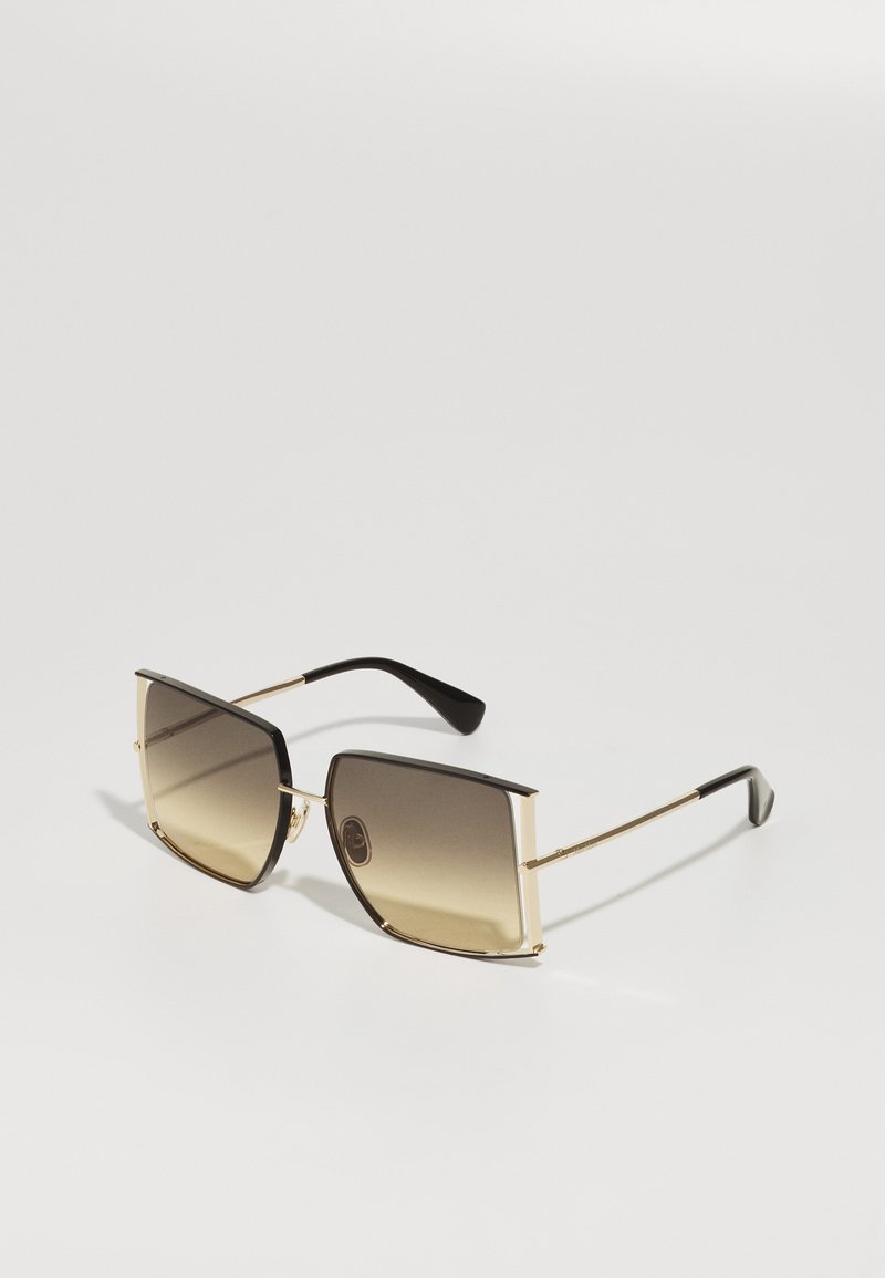 Occhiali da sole con montatura quadrata in metallo con accenti dorati e lenti gradiente marroni. Tempi neri con una finitura lucida.