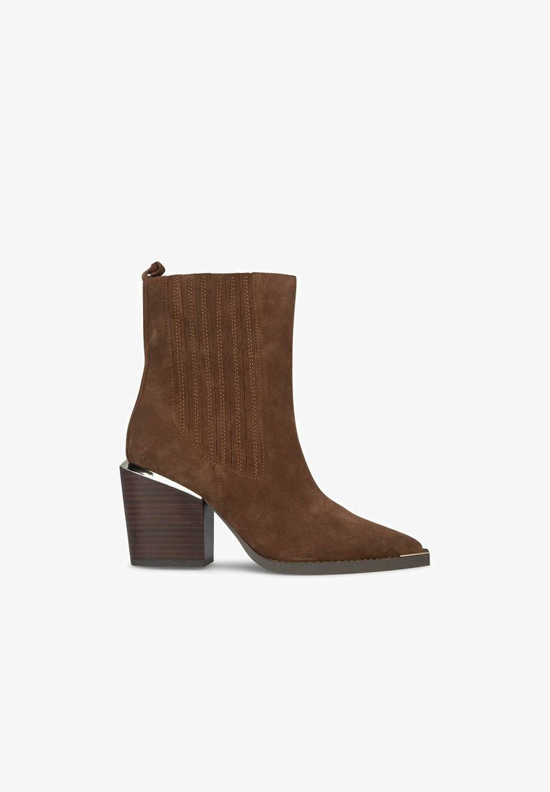 Braune Wildleder-Stiefelette mit spitzem Zeh, vertikalen Nahtdetails und einem gestapelten Holzhaken mit einem glänzenden Chromakzent.