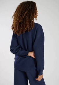 Pullover overdimensionato blu navy con maniche lunghe e vestibilità comoda, realizzato in morbido tessuto tessurizzato. Presenta polsini a costine e orlo dritto.
