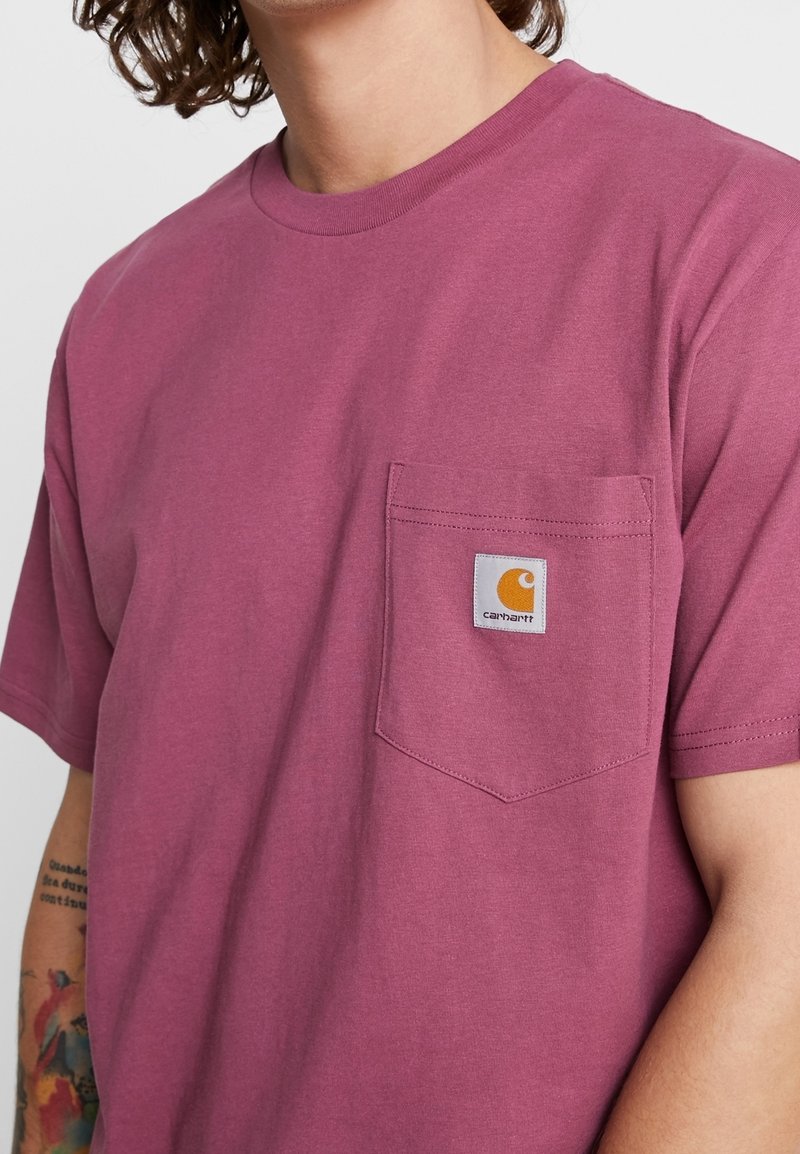 Kurzärmliges T-Shirt mit Rundhalsausschnitt in tiefem Mauve, aus Baumwolle, mit einer Brusttasche, die ein Carhartt-Logo-Label trägt.