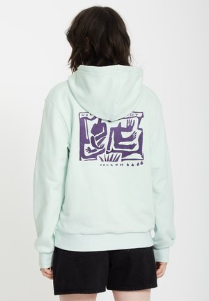 Sudadera de color verde menta claro con un gran gráfico morado en la parte posterior, que presenta figuras abstractas, puños acanalados y capucha con cordón.