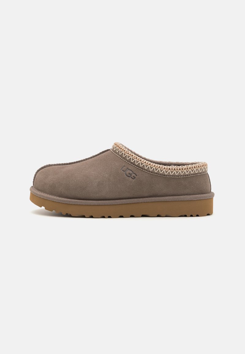 Brown suede clog with a textured collar, rubber sole, and embroidered detailing. Features rounded toe and low-profile design.