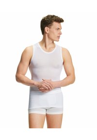 Biały top na ramiączkach wykonany z lekkiego materiału z okrągłym dekoltem, zestawiony z białymi szortami bokserskimi. Oba elementy są dopasowane z minimalną ilością szwów.
