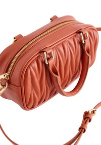 Torebka z pomarańczowej pikowanej skóry z złotym zamkiem, podwójnymi uchwytami i regulowanym paskiem. Posiada teksturowaną powierzchnię i kompaktowy prostokątny kształt.