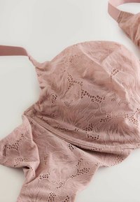 Lace bh in zachtroze met bloemenpatroon. Voorzien van dunne bandjes, golvende randen en een gladde textuur. Gevoerde cups met delicate details.