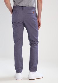 Slim-fit kalhoty z texturované fialové látky se jemným vzorem rybí kosti, s dvěma zadními kapsami a malým logem značky.