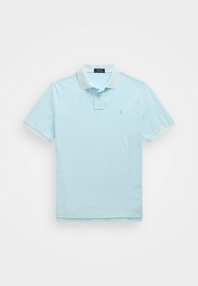 Polo de culoare albastru deschis, fabricat din bumbac moale. Are un guler clasic, o deschidere cu două butoane și un mic logo brodat pe piept.