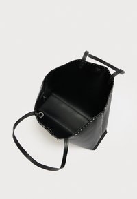 Čierna kožená taška cez rameno s cvokmi a textúrovaným povrchom. Otvorený vrch, dve rukoväte a priestranné, nevybavené vnútro.