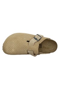 Chausson en suède beige avec un design perforé, une large boîte à orteils et une sangle réglable avec une boucle en métal. Semelle plate avec un faible relief.