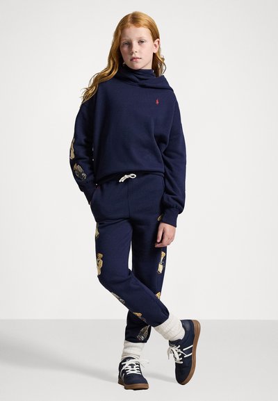 Námořnický modrý svetr a odpovídající kalhoty, oba z měkké tkaniny, s vyšívanými motivy medvědů, s pohodlným stojáčkem a stahovacími šňůrkami v pase.