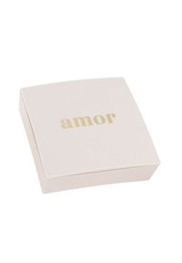Caja cuadrada de color crema con una textura suave y un acabado ligeramente brillante, que presenta la palabra "amor" en letras doradas y en negrita en la tapa.