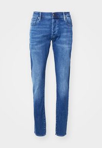 Blå denimjeans med rak skärning, femfickorsdesign och dragkedja med knappstängning. Blekt mönster för en slitna look.