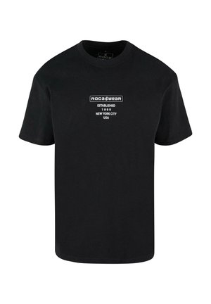 Black cotton t-shirt with short sleeves, featuring white text logo "ROCA WEAR," established 1999, New York City, USA on the front.