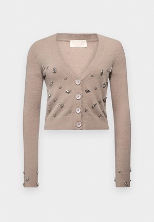 Beige cropped cardigan made of soft material, featuring a deep V-neck, five buttons, and decorative silver embellishments on the front and sleeves.