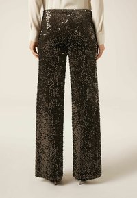 Zwarte pantalon met brede pijpen, versierd met pailletten, voorzien van een gladde tailleband. De broek heeft een textuur en een dramatische, vloeiende silhouette.