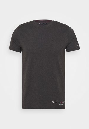 T-shirt gris foncé à manches courtes et col rond avec petit logo Tommy Hilfiger et texte proche de l'ourlet inférieur et sur la manche gauche.